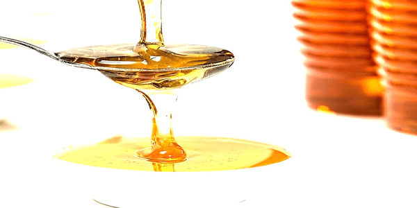 Honey getting poured on a spoon
